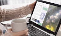 a woman is using a laptop with a cup of coffee